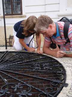 Ciska en Arjan kijken in de wensput bij het bisschoppelijk paleis